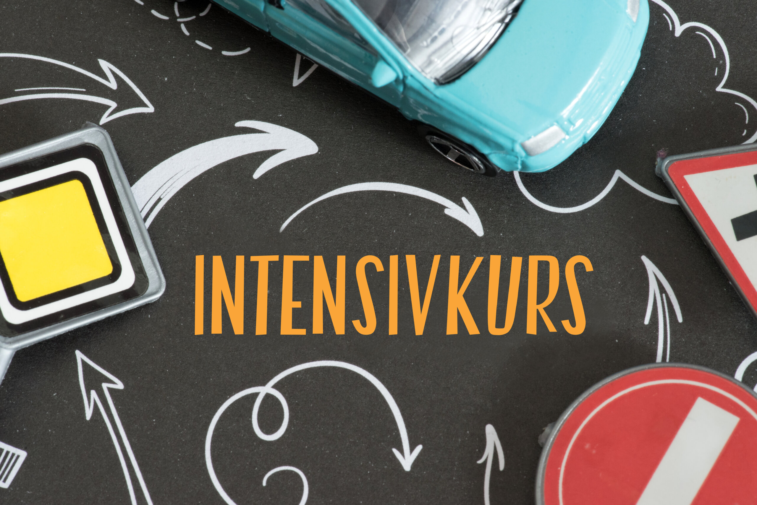 Ein Auto, Verkehrsschild und Intensivkurs beim Führerschein