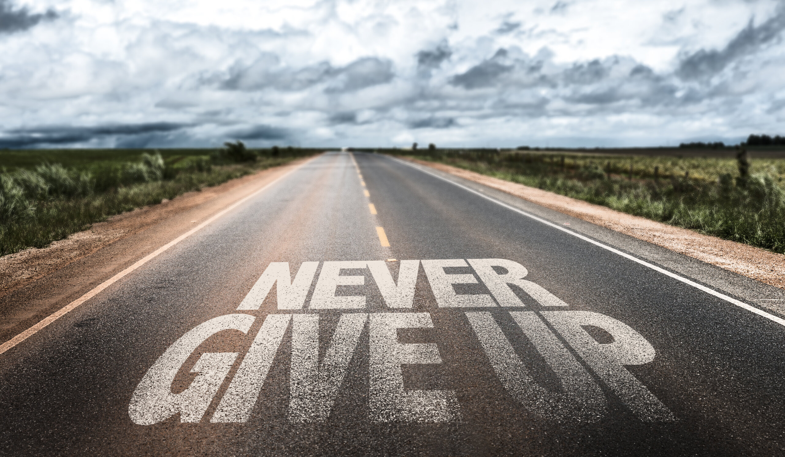 Never Give Up written on rural road
